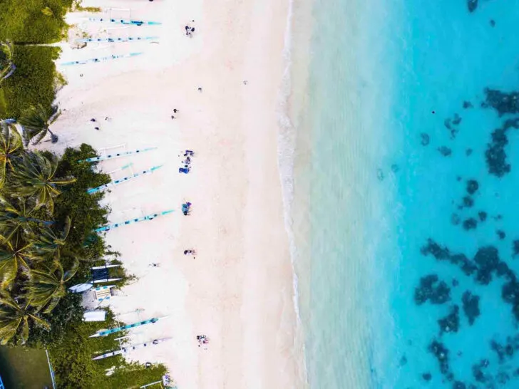 warm places to visit in October in usa view of beach looking down with palm trees and blue water