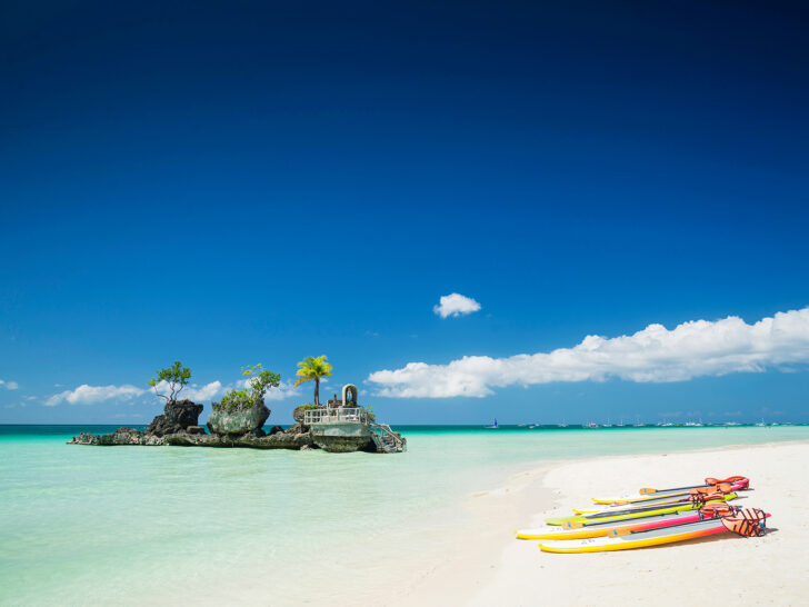 bright sea with kayaks on white sand and rocks 40th birthday vacation ideas