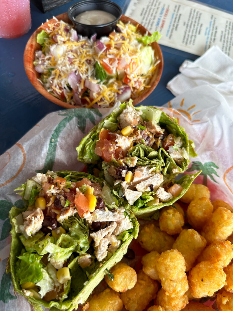 salad bowl, chicken wrap and tater tots on table vieques or culebra