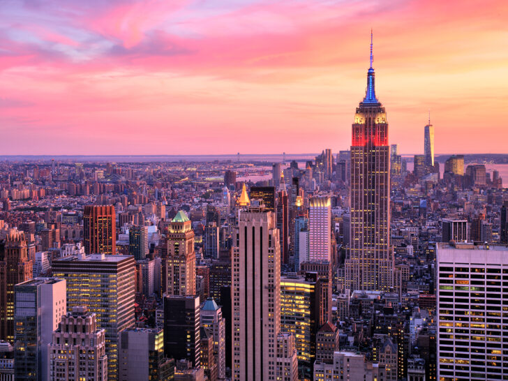 New York City skyline with pink sky and buildings lit up