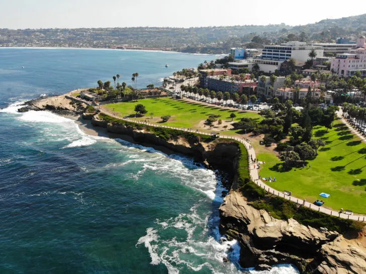 california shoreline with ocean trees grass and buildings along coast