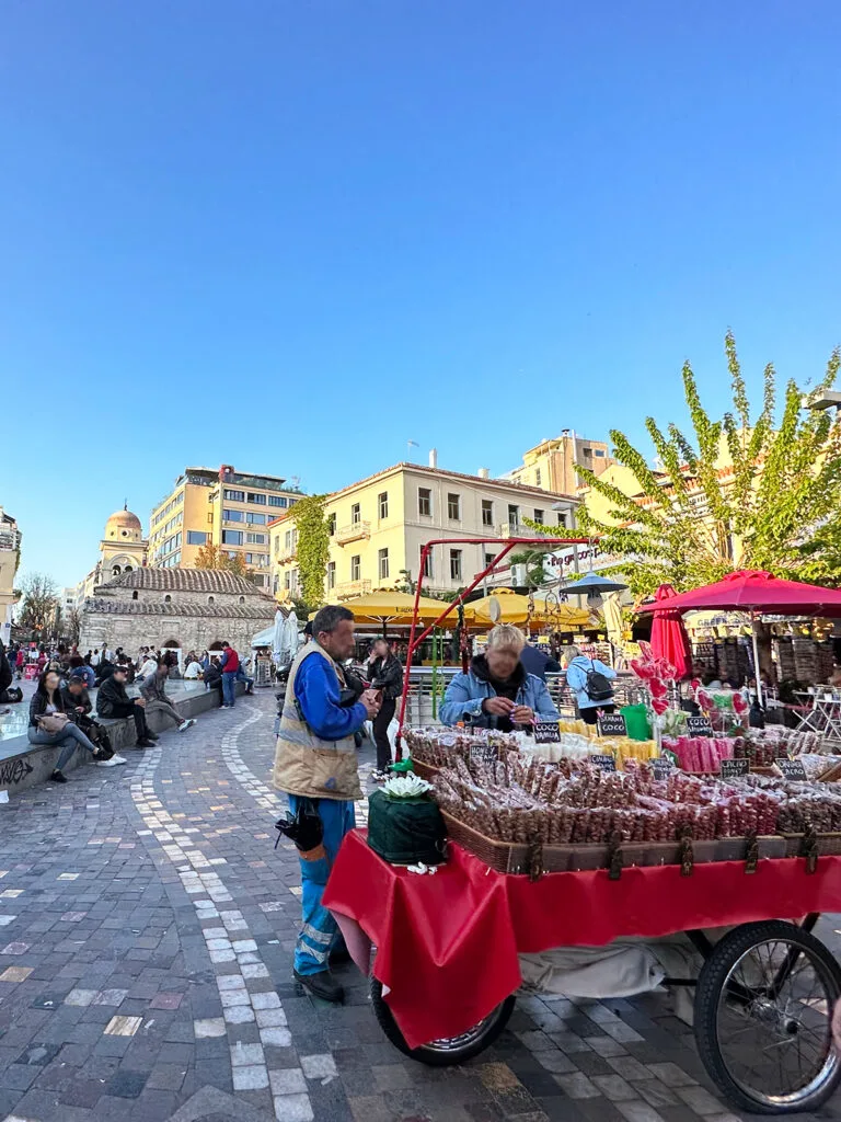 cart full of food on city street center with buildings and people surrounding it