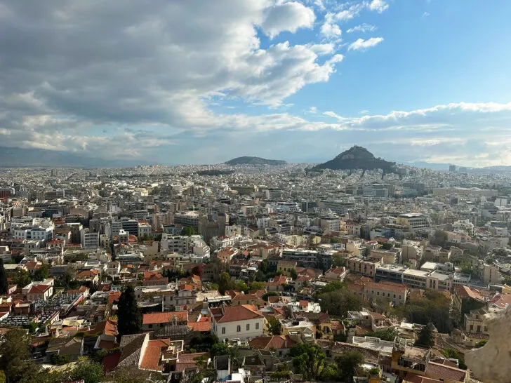 view of city from hilltop with two hills in distance