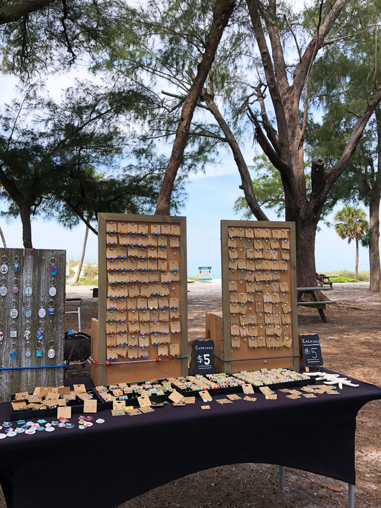 craft fair jewelry on table with trees in distance