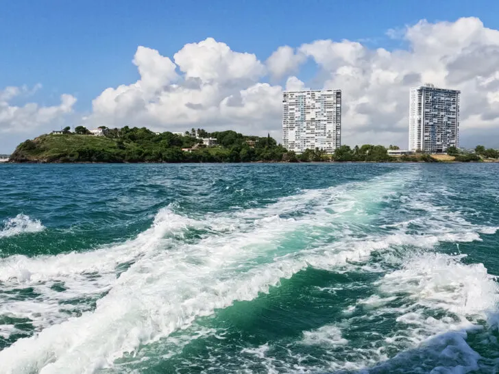 Puerto Rico boat tour view of water and coastline with 2 tall buildings