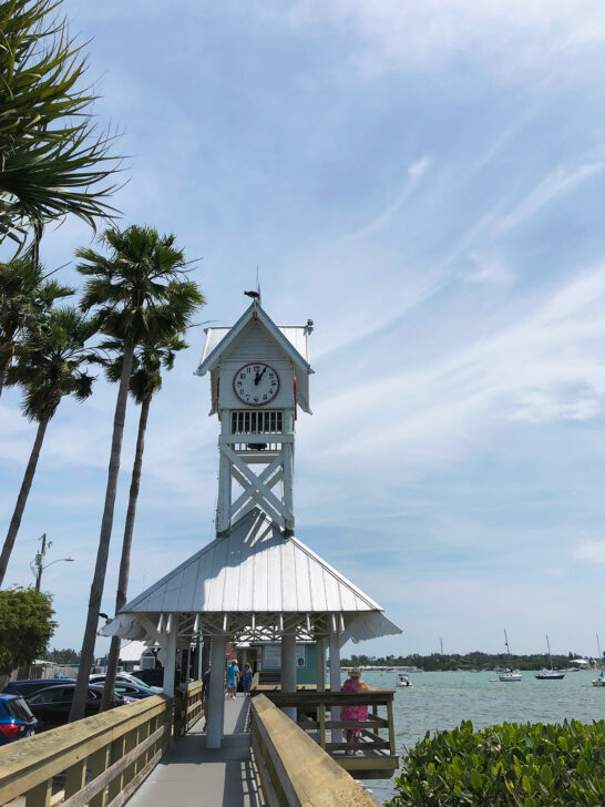 what to do in Anna Maria island view of boardwalk with clock tower near bay