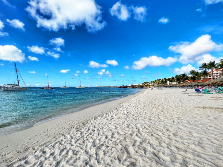 Aruba's white sand beach in winter time with hotels and boats off shore best countries to visit in February 