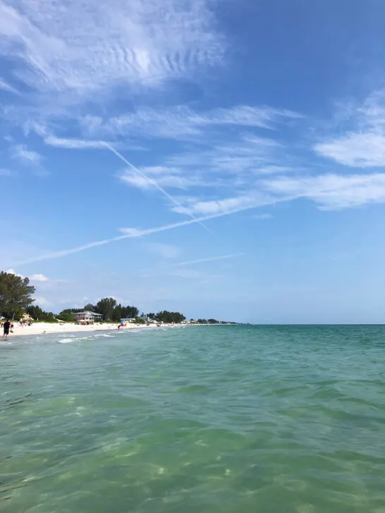 teal water and beach with blue sky