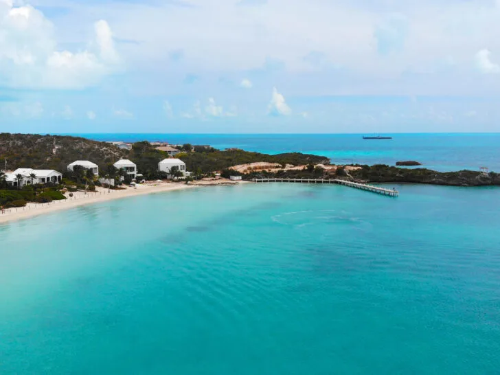 best Turks and Caicos beaches Sapodilla Bay Providenciales with view of teal water and white houses along coast
