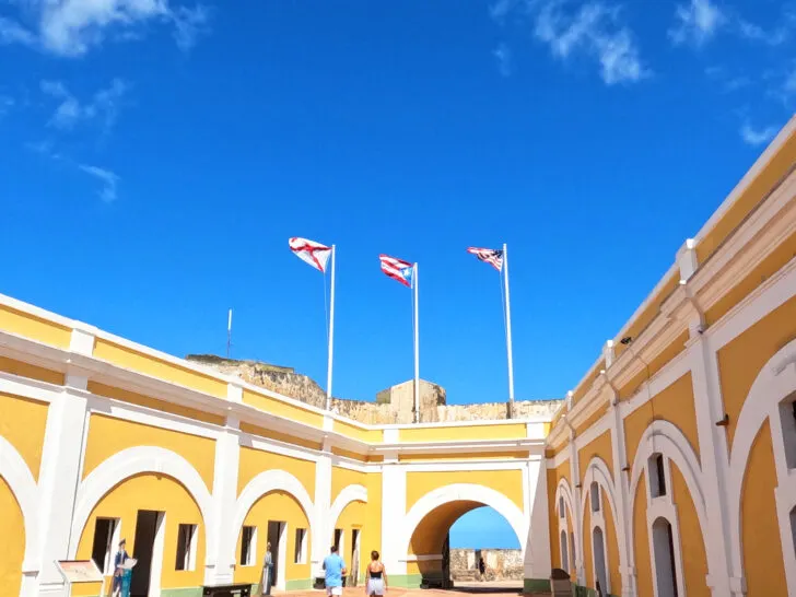 old San Juan fort with yellow building arches and doors with flags
