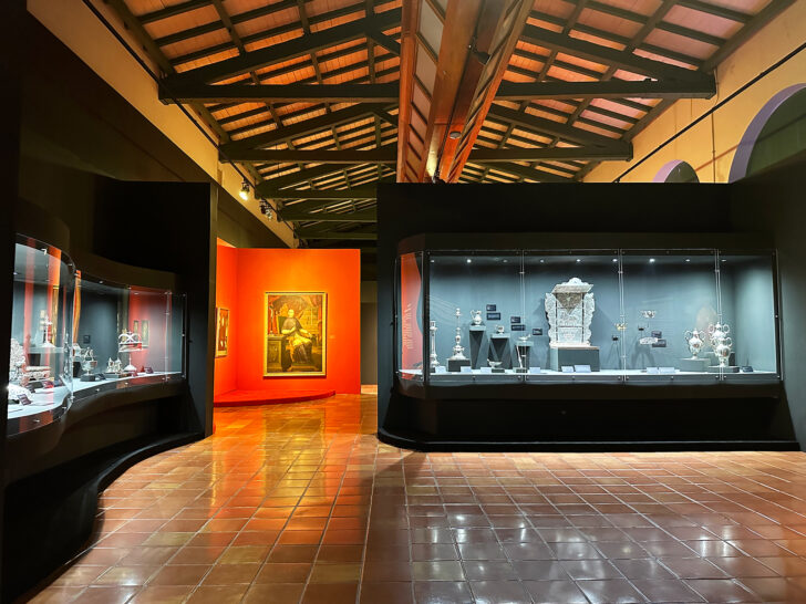 view of museum interior with display cases and paintings