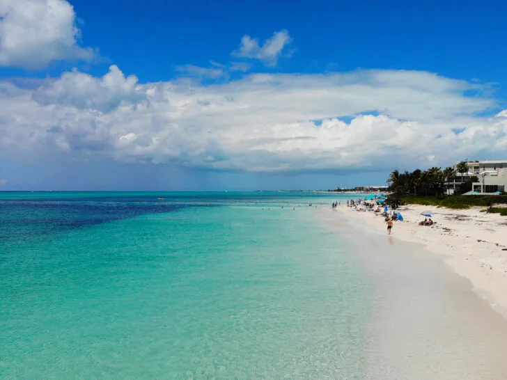 teal water white sand blue sky white cloud at best Turks and Caicos beaches