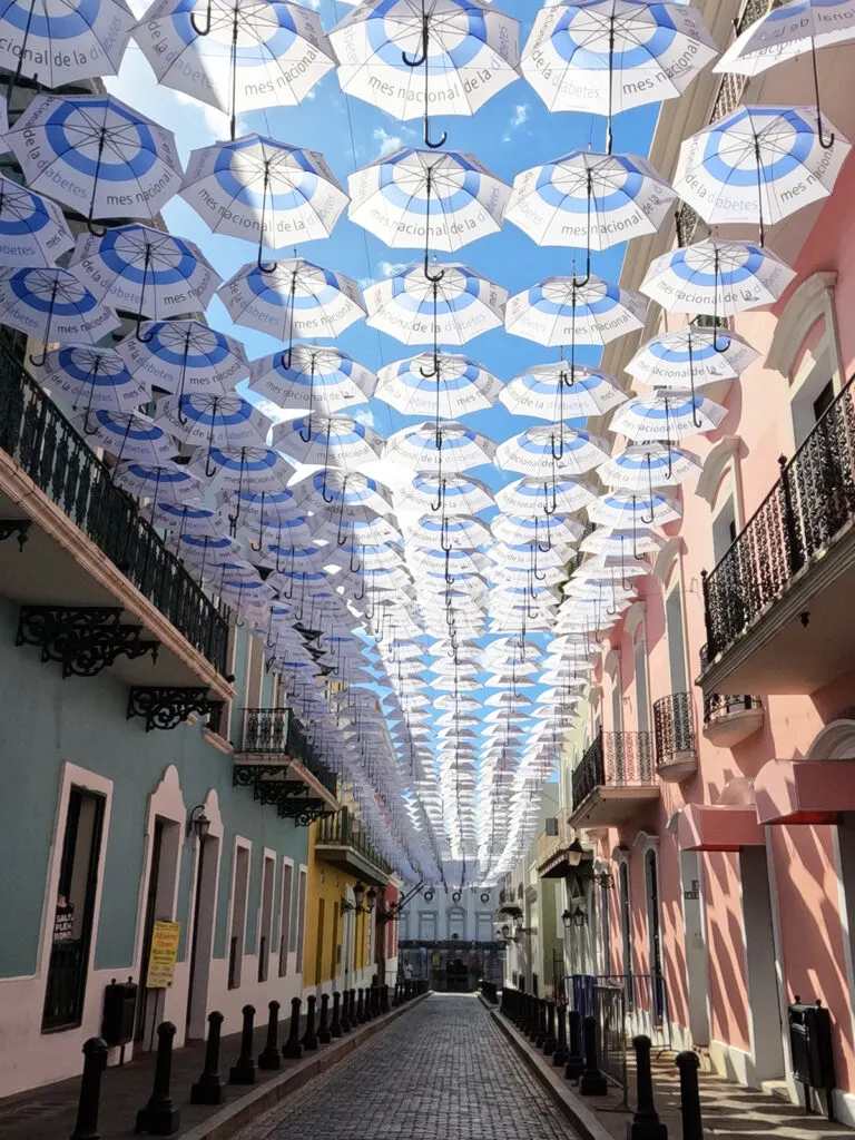 old San Juan walking tour view of umbrellas hovering over street with colorful buildings