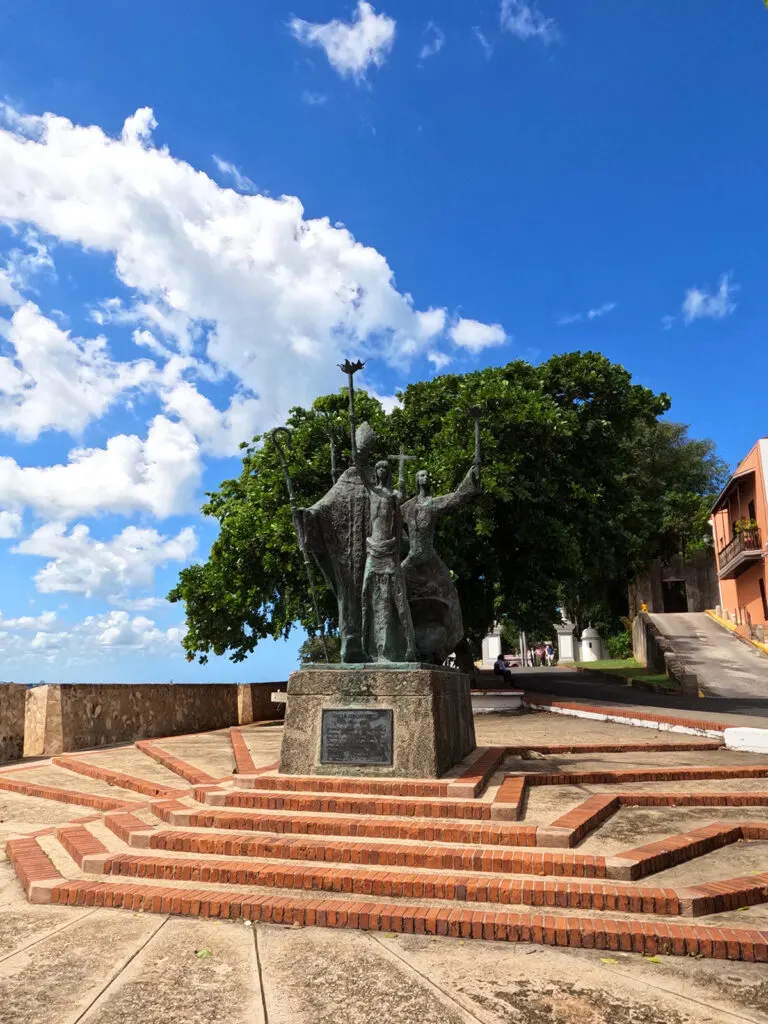 old San Juan things to do view of statue in plaza with steps and trees