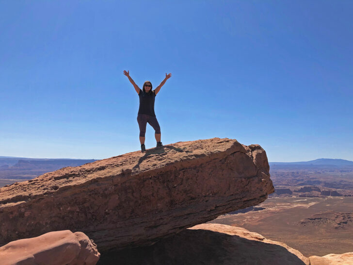 woman standing on large rock in Canyonlands National Park near Moab UT