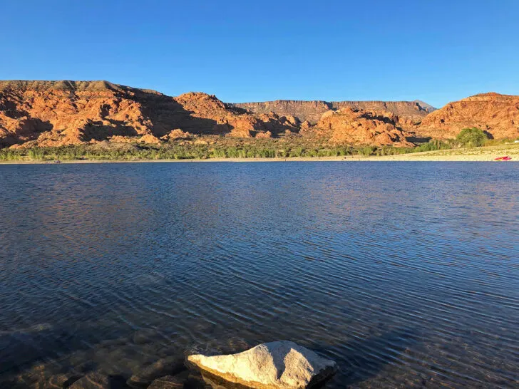 Kens Lake best things to do in Moab view of rock in blue water with plateau in distance