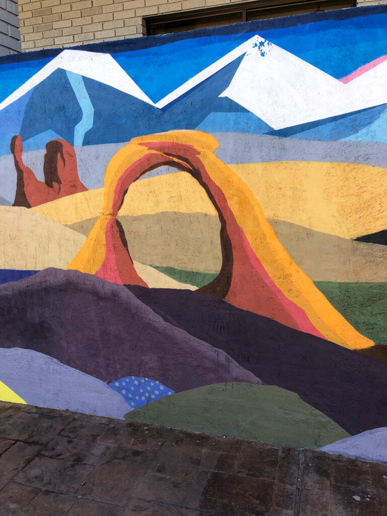 painted mural with arch and hills things to do Moab