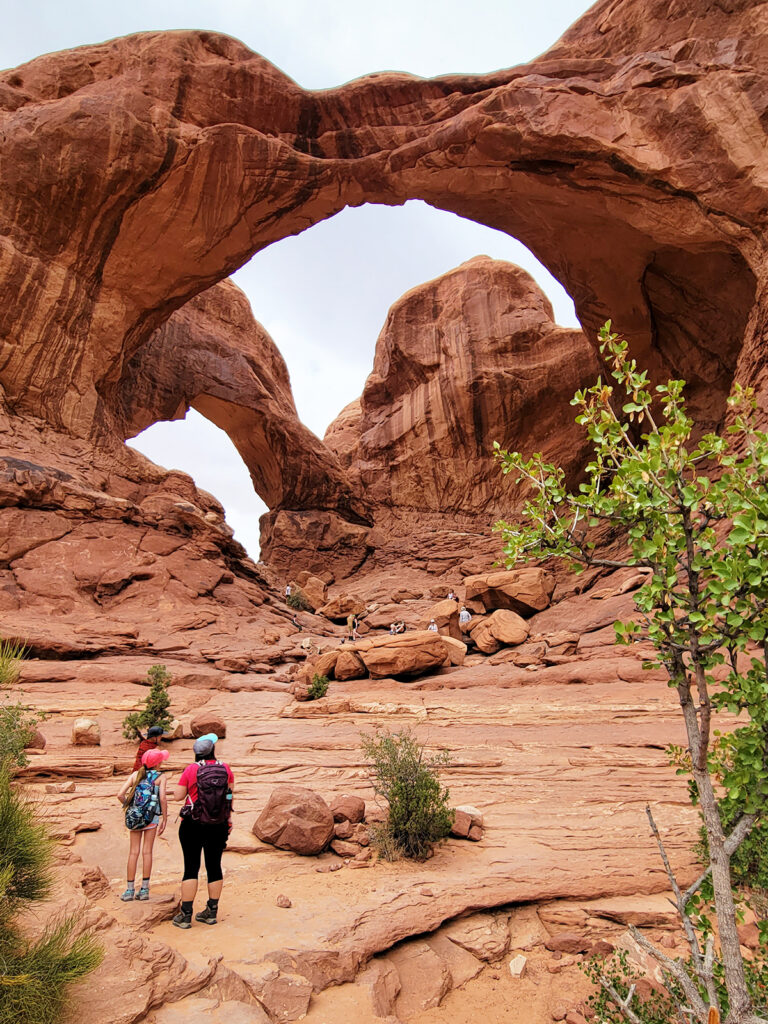 woman and child standing in front of large arch things to do Moab UT