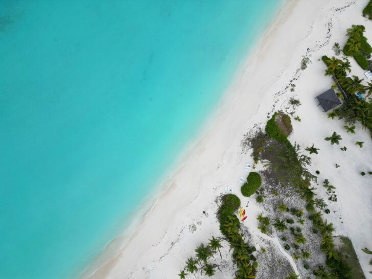 can you fly a drone in the Bahamas view of teal water white sand and palm trees from above
