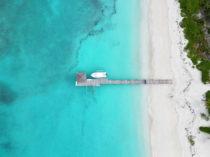can you fly a drone in the Bahamas view of pier with boat and teal water looking down