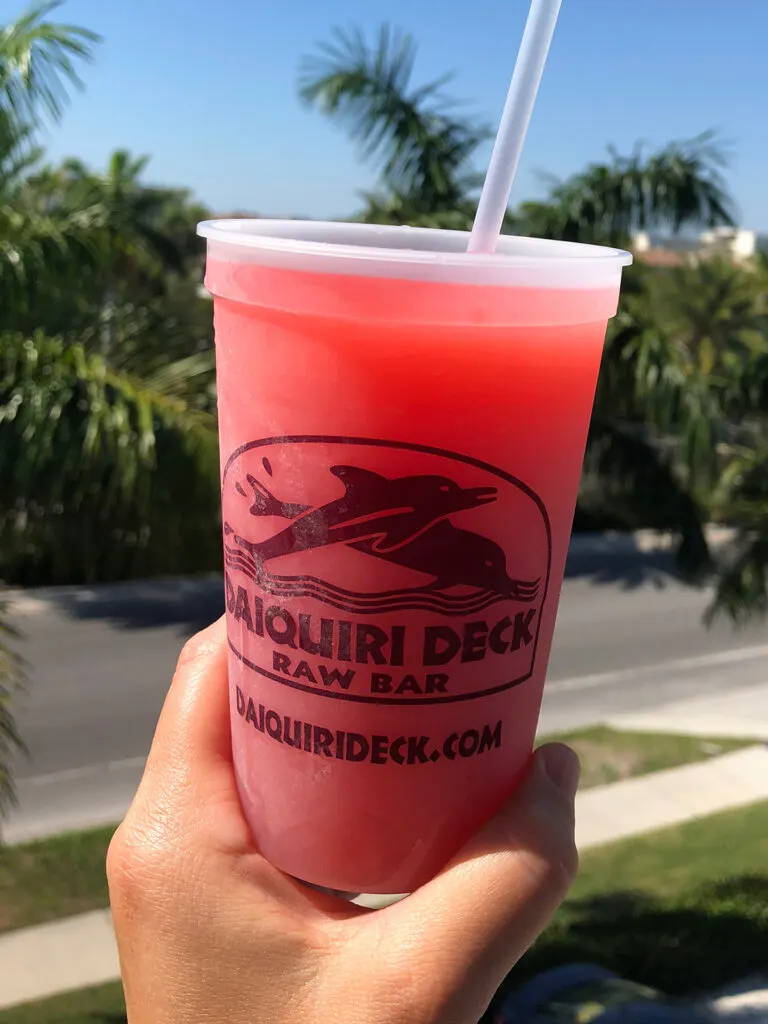 things to do in Siesta Key visiting Daiquiri Deck holding pink drink in cup
