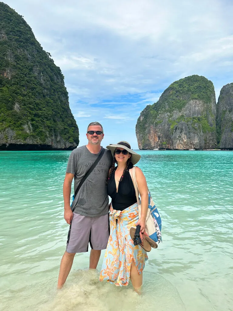 couple in ocean with teal water and karsts surrounding