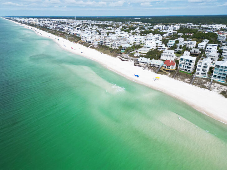 30a Florida beaches view of Inlet Beach with emerald colored water bright white sand and large houses along shoreline