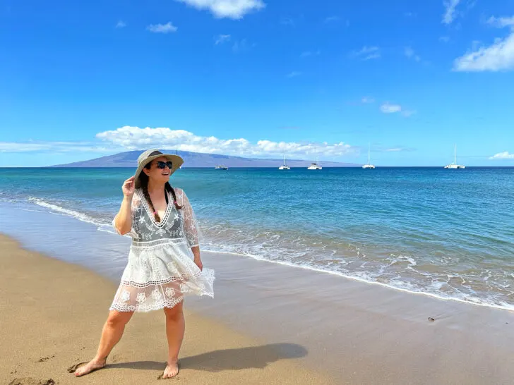 woman wearing swim suit cover on beach in Maui Hawaii with ocean in background what to pack for the beach