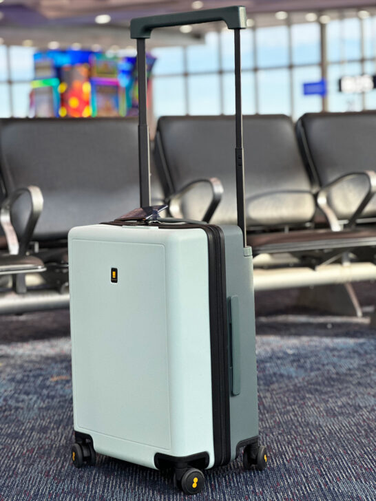 green suitcase sitting on airport floor