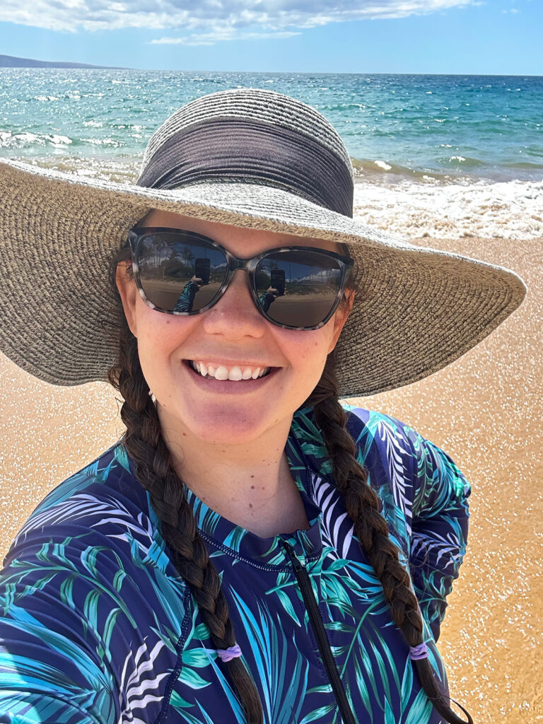 woman wearing sun hat and printed swimming suit what to wear in Hawaii
