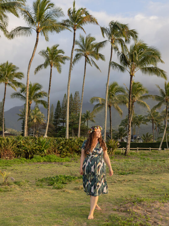 woman walking in green dress with palm trees behind what to wear in Hawaii female