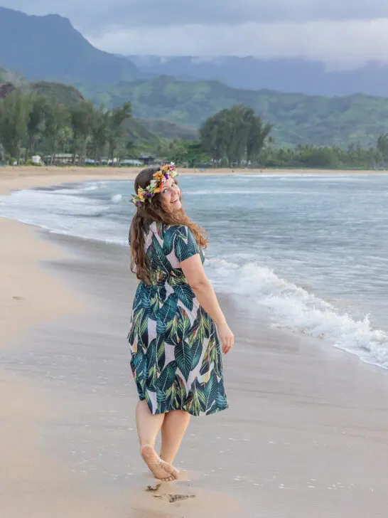 woman walking on beach in dress with ocean in distance