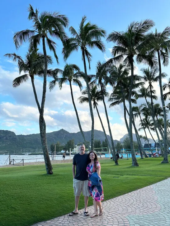 luau attire couple standing in front of palm trees dressed nicely