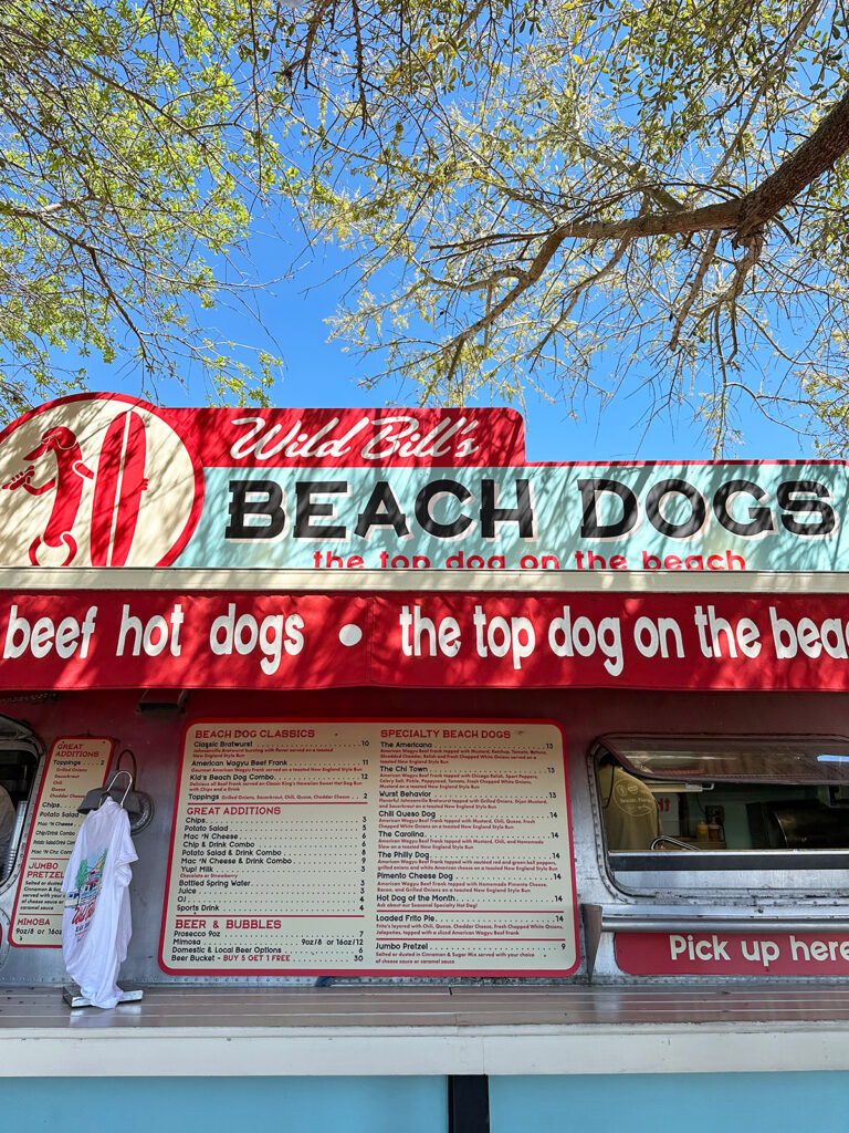 seaside restaurant front with ordering menu and sign that reads Wild Bill's Beach Dogs the top dog on the beach