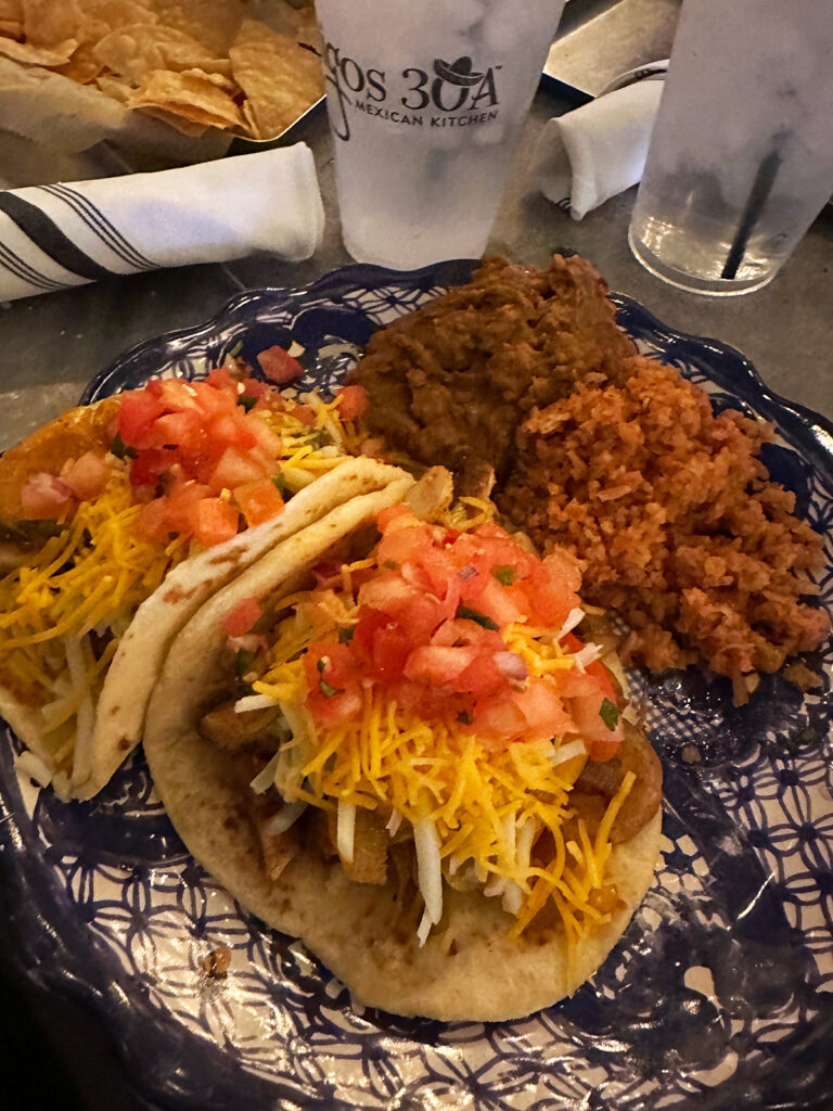 tacos beans and rice on blue plate at mexican place