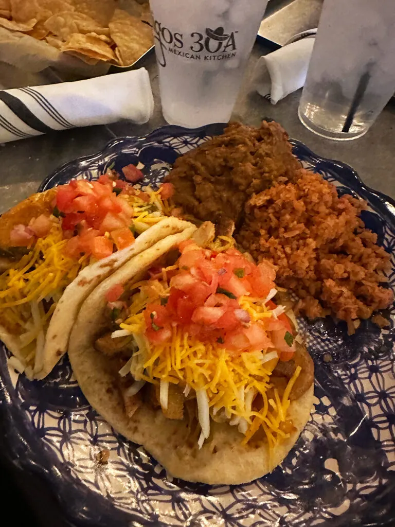 tacos beans and rice on blue plate at mexican place