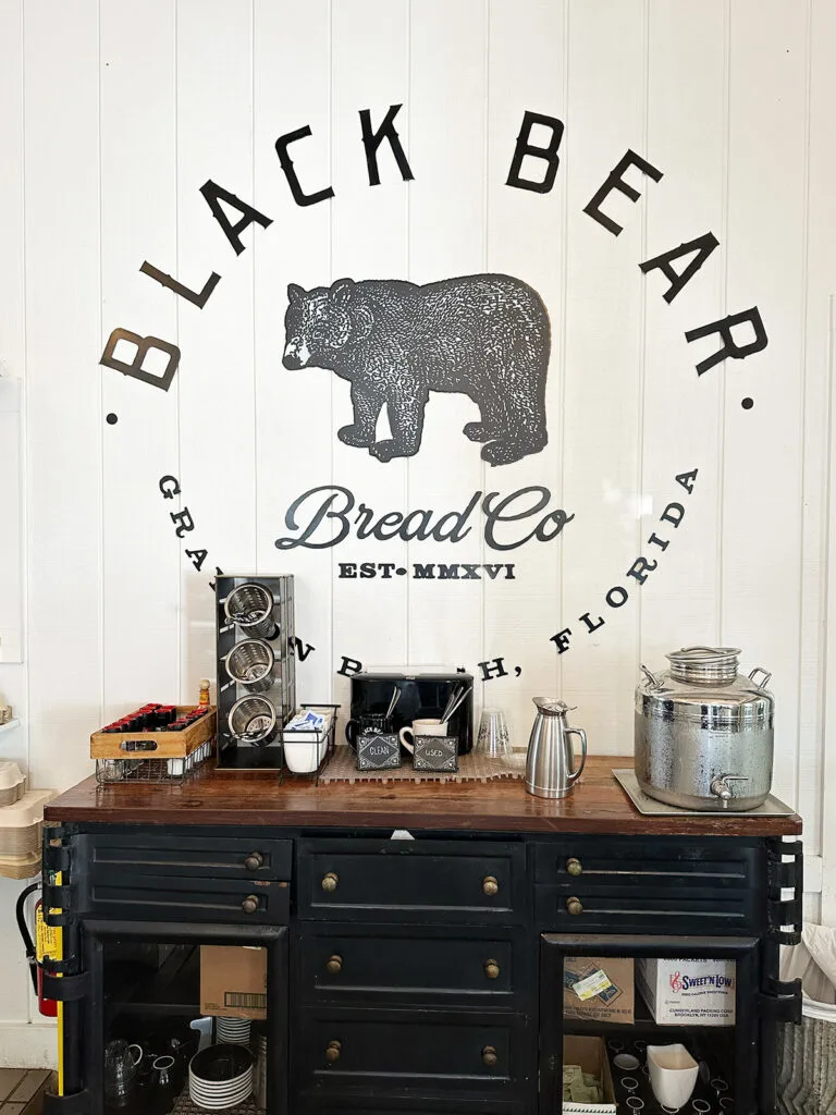 sign that reads black bear bread co grayton beach florida with coffee stand below