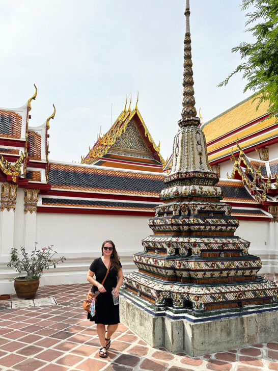 enjoying two days in Bangkok woman in black dress standing near large pillar shaped statue