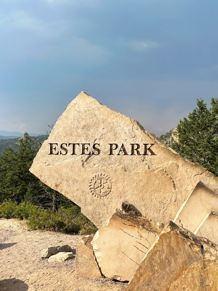 sign carved on rock that reads Estes Park best mountain towns in colorado 