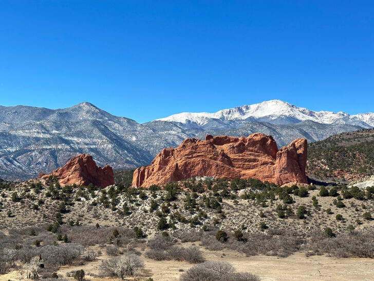 red rocks with snow-capped mountains in distance