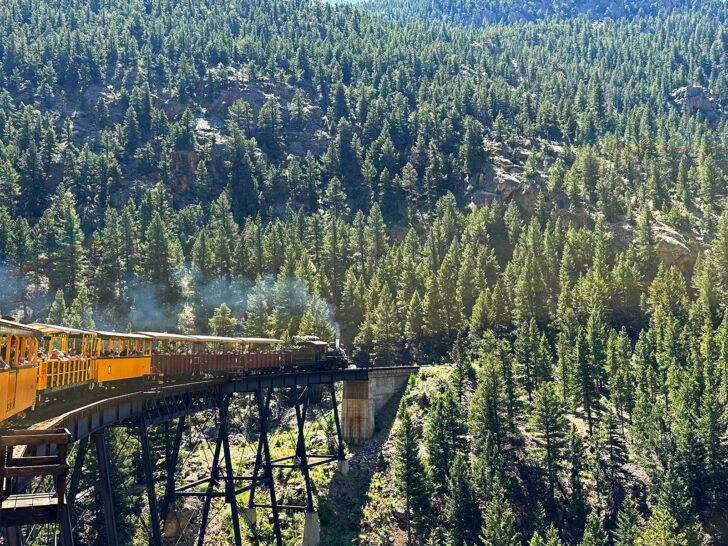 adorable mountain towns in Colorado view of train on tracks going into trees in Georgetown