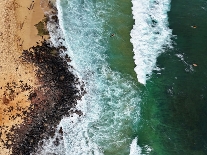 surfers on waves in Kauai hawaii Kauai drone photography