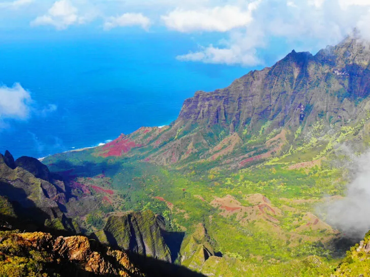 kauai drone photography view of napali coast with multicolored landscape and clouds and ocean