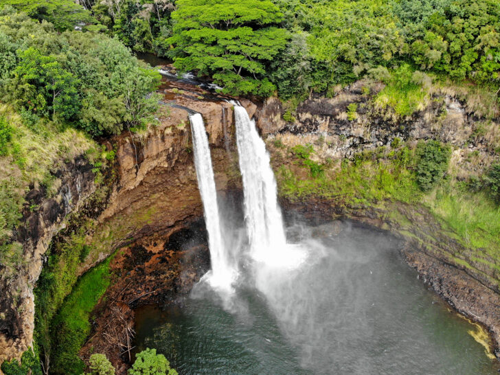 waterfall drone photo in Hawaii with tropical landscapes surrounding