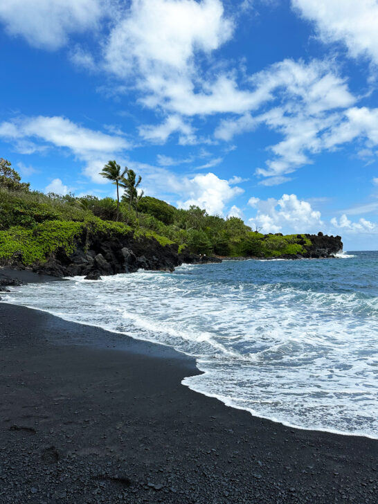 black sand white waves and green coast view of best thing to do in Hana black sand beach