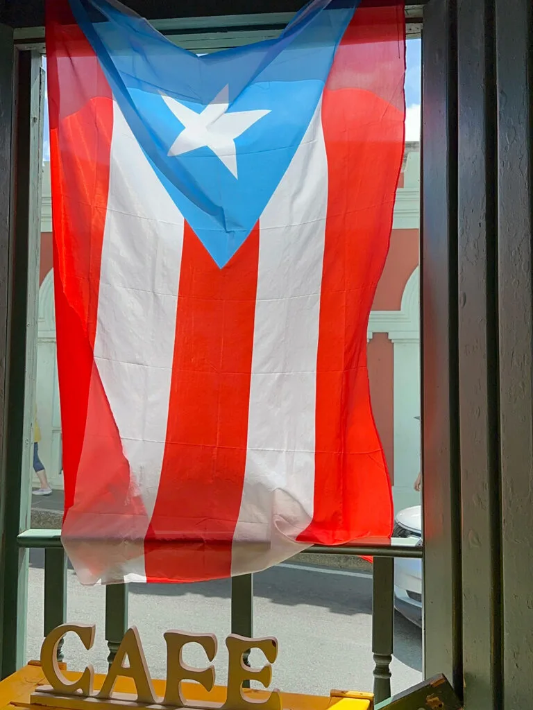 Puerto Rico flag hanging in window with the words cafe underneath