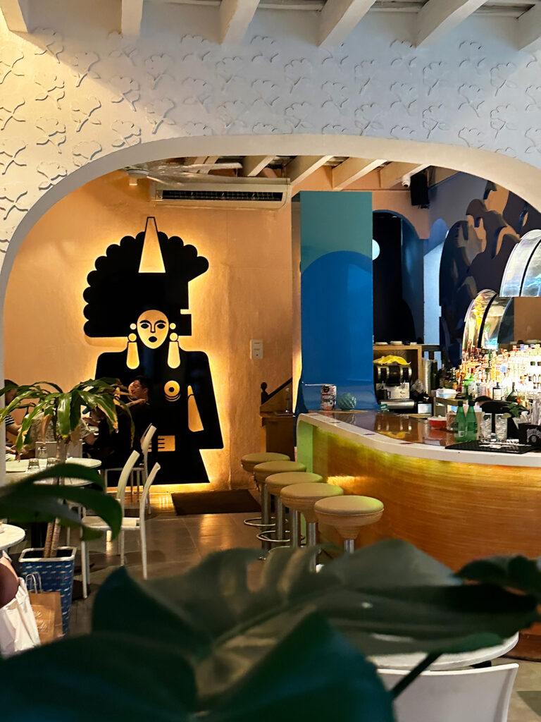 interior of restaurant with bar and woman mural