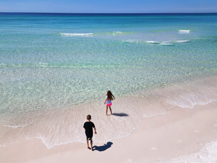 30A Florida spring break with kids view of the blue ocean and white sand with two kids near shore