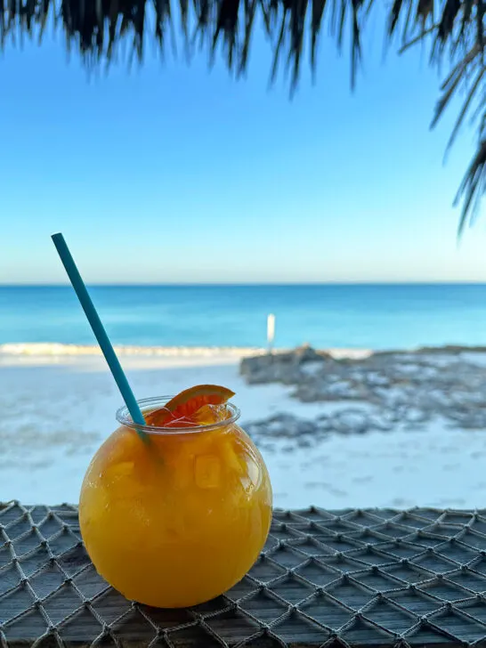 drink in little Exuma with beach in distance at dusk