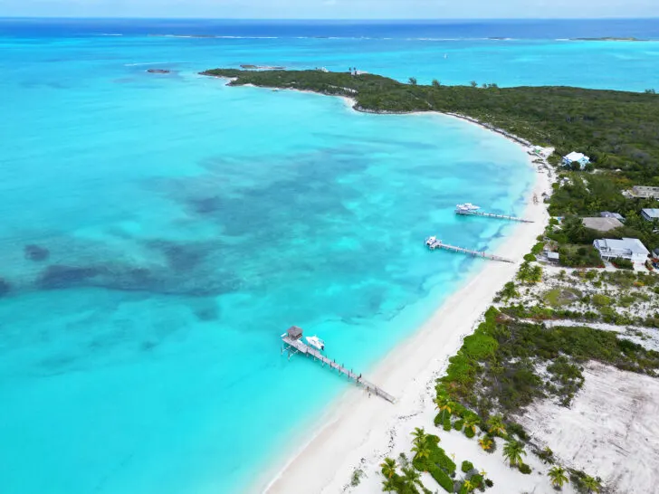 view of three docs on curved coastline in exumas bahamas